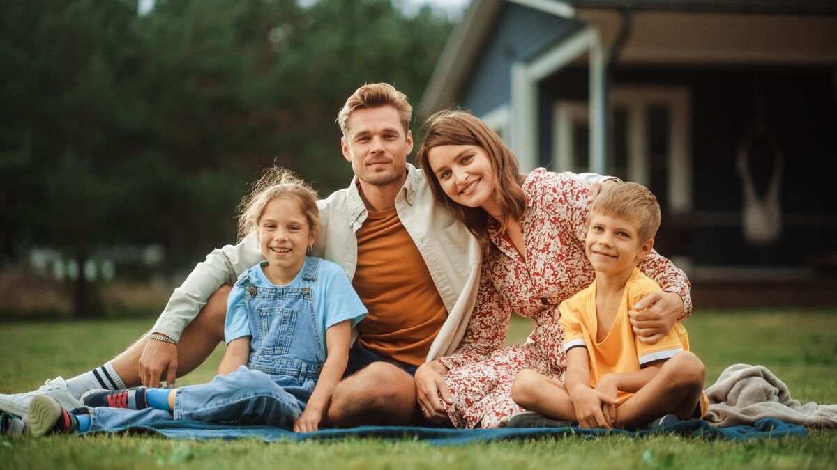 Happy family sitting together outside their home